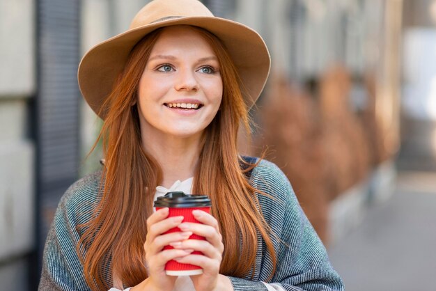 Smiley kobieta trzyma filiżankę kawy