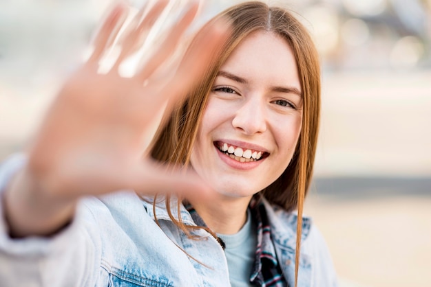 Bezpłatne zdjęcie smiley kobieta z ręką uniesioną do góry