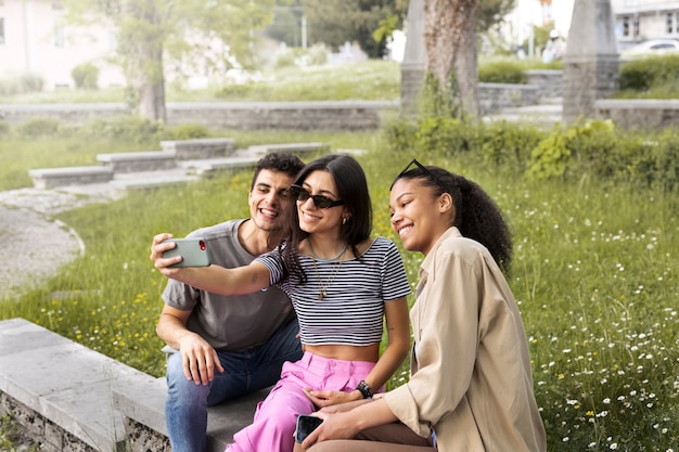 Bezpłatne zdjęcie smiley przyjaciele robią selfie widok z boku