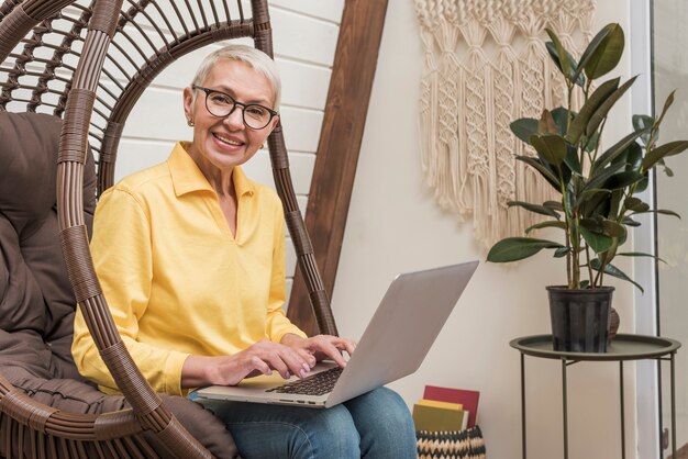 Smiley starsza kobieta pracuje na jej laptopie