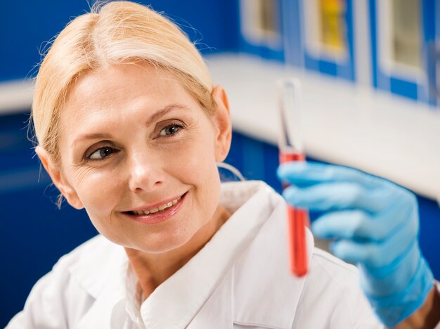 Smiley żeński naukowiec trzyma laboranckiego przedmiot