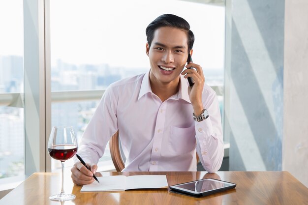 Smiling Azjatycki biznesmen rozmawiać na Smartphone