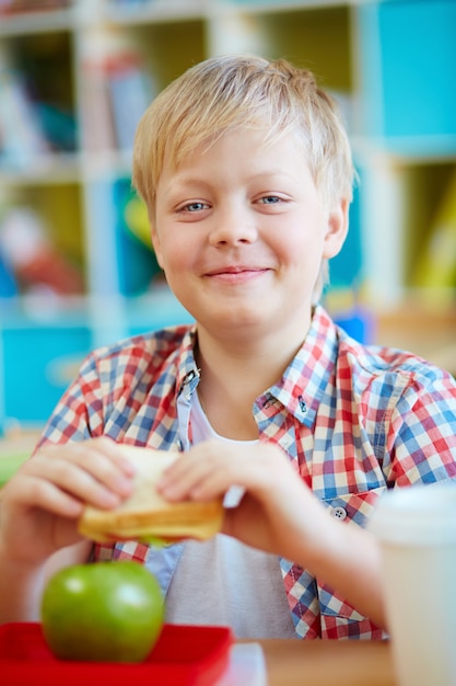 Bezpłatne zdjęcie smiling uczniak jedząc obiad