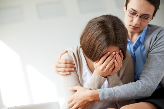 Smutna kobieta płacze obok swojego terapeuty