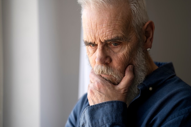 Bezpłatne zdjęcie smutny starszy mężczyzna w domu