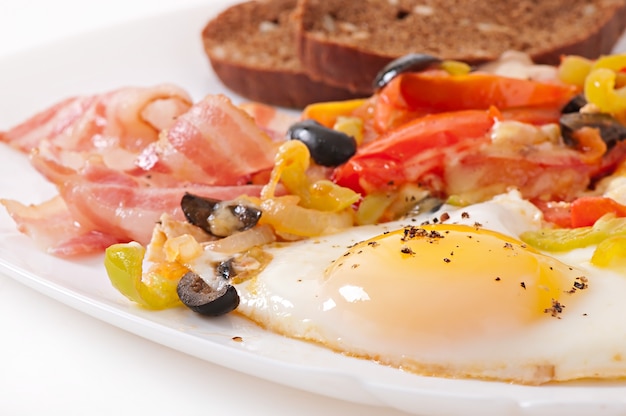 Śniadanie - jajka sadzone z boczkiem, pomidorami, oliwkami i plasterkami sera