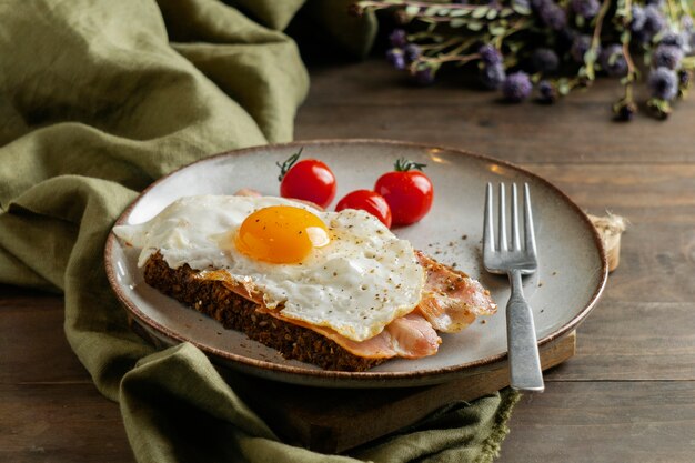 Śniadanie z jajkiem, boczkiem i pomidorami