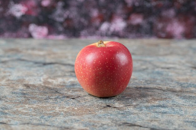 Soczyste jabłko na białym tle na betonowym marmurze.