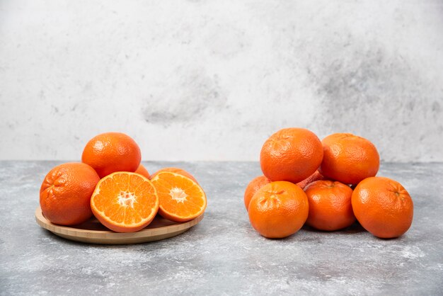 Soczyste pomarańczowe owoce z plastrami na kamiennym stole.
