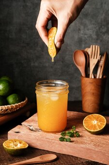 Sok pomarańczowy w szklance ze świeżymi owocami na stole selektywne skupienie i rozmyte tło