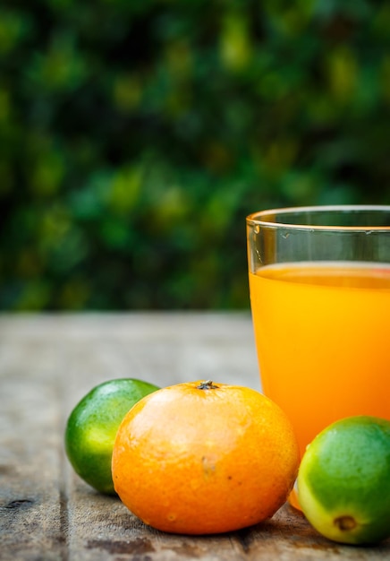 Bezpłatne zdjęcie sok pomarańczowy z cytryną, limonką i miętą na drewnianej desce
