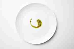 Bezpłatne zdjęcie sos pesto na białym pustym talerzu na białym tle widok z góry