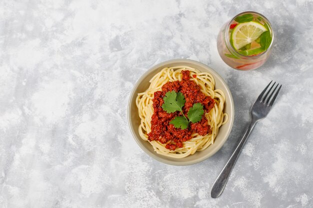 Spaghetti Bolognese i lemoniada na szarym betonie