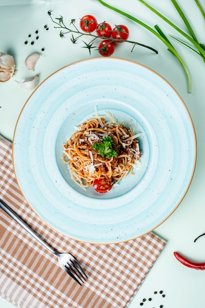 Bezpłatne zdjęcie spaghetti bolognese zwieńczone serem i ziołami