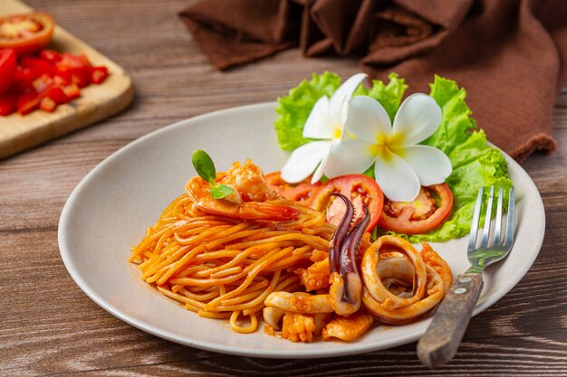 Spaghetti z owocami morza w sosie pomidorowym Udekorowane pięknymi składnikami.