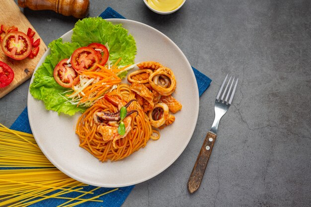 Spaghetti z owocami morza w sosie pomidorowym Udekorowane pięknymi składnikami.