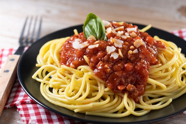 Spaghetti z sosem bolognese na drewnianym stole