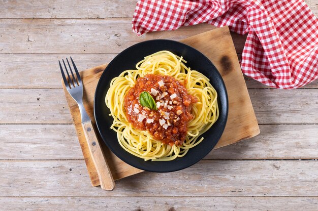 Spaghetti z sosem bolognese na drewnianym stole