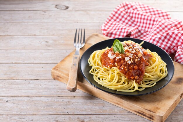 Spaghetti z sosem bolognese na drewnianym stole