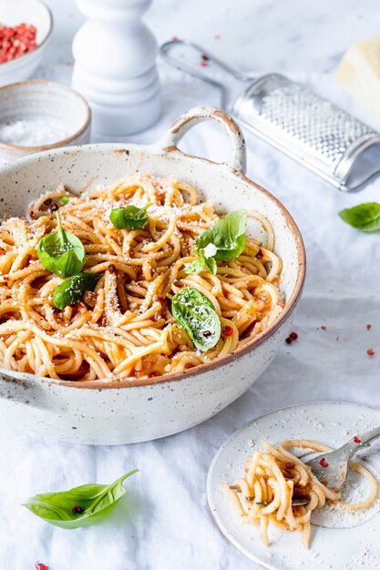 Spaghetti z sosem pomidorowym marinara polane parmezanem i bazylią fotografia kulinarna