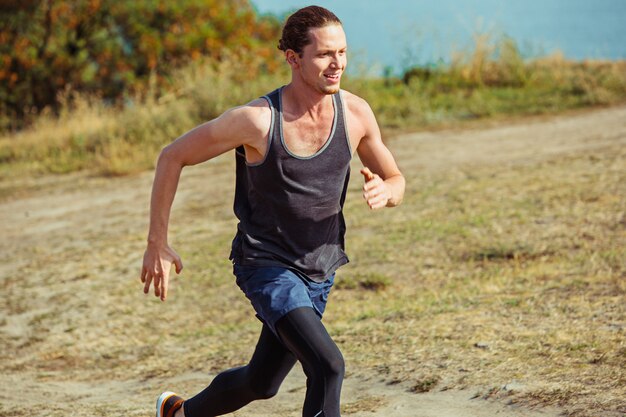 Sport biegowy. Biegacz człowiek sprint na świeżym powietrzu w malowniczej przyrody. Dopasuj muskularny mężczyzna sportowca szlak treningowy do biegania w maratonie.