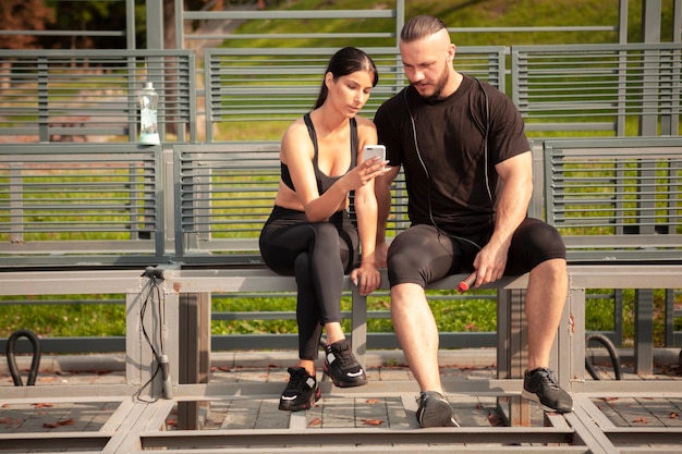 Sportive przyjaciół na stadionie patrząc na telefon