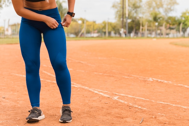 Sportowa kobieta stoi na torze stadionu