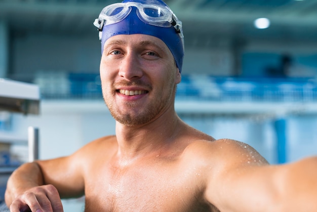 Sportowa męska pływaczka bierze selfie