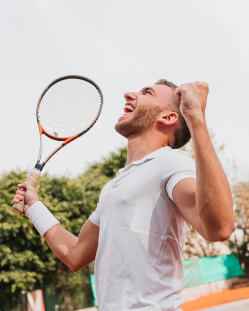 Sportowa młoda chłopiec wygrywa tenisową grę