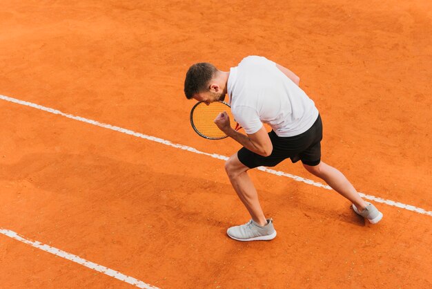 Sportowa młoda chłopiec wygrywa tenisową grę