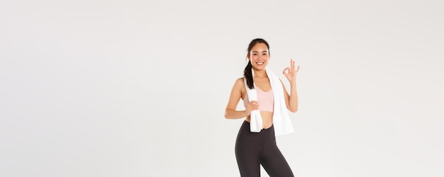 Sportowa siłownia i koncepcja zdrowego ciała na całej długości zadowolonej uśmiechniętej lekkoatletki słodkie azjatyckie dziewczyny s