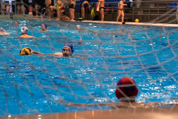 Bezpłatne zdjęcie sportowcy grający w piłkę wodną w basenie