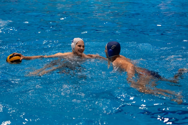 Sportowcy grający w piłkę wodną w basenie