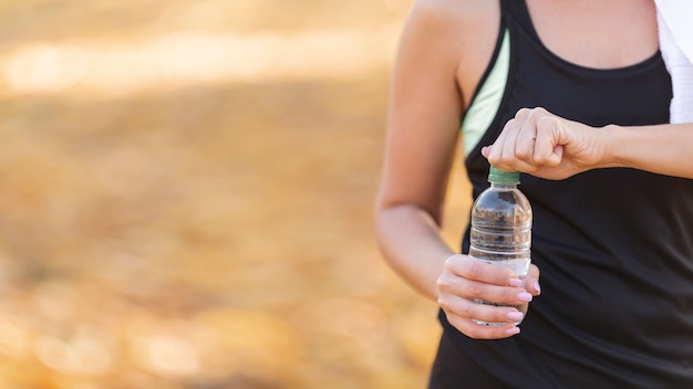 Bezpłatne zdjęcie sportowe ciało trzyma butelkę wody