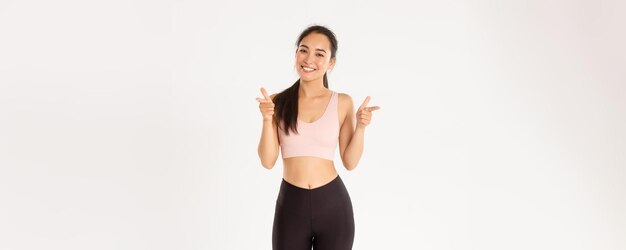 Sportowe samopoczucie i koncepcja aktywnego stylu życia wesoła uśmiechnięta urocza azjatycka dziewczyna fitness trener siłowni lub s