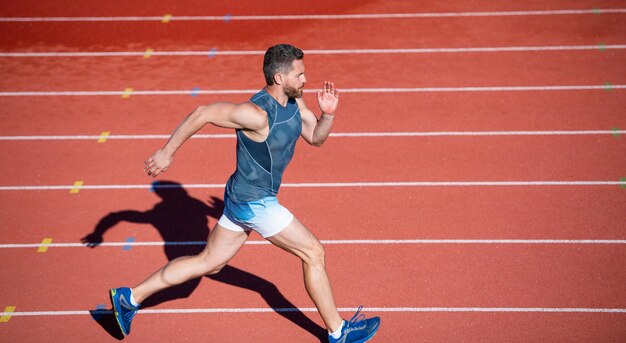 Sportowiec mężczyzna w odzieży sportowej biegać szybko sprintem na bieżni, dystans.