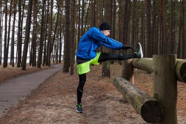 Sportowiec rozciągający się w lesie