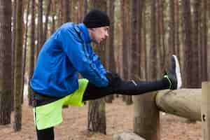 Bezpłatne zdjęcie sportowiec rozciągający się w lesie