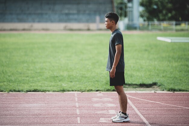 sportowiec stojący na bieżni na każdą pogodę