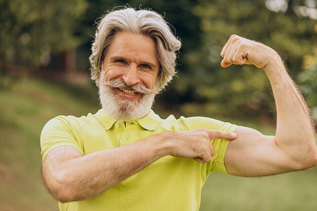 Sportowiec w średnim wieku, wskazując na biceps