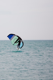 Sportowiec z skrzydełkiem żegluje po morzu