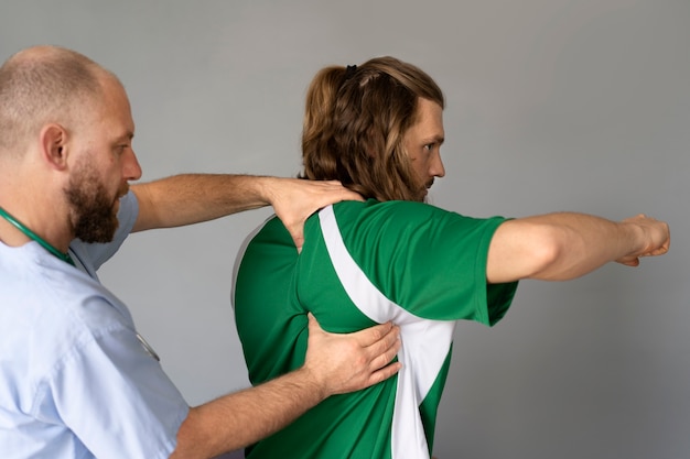 Bezpłatne zdjęcie sportowiec z widokiem z boku robi fizjoterapię
