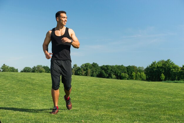 Sportowy mężczyzna biega plenerowy w parku