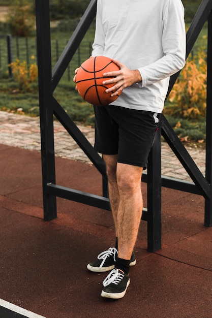 Bezpłatne zdjęcie sportowy mężczyzna trzyma koszykówkę
