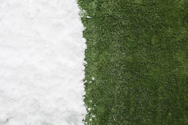 Spotkanie biały śnieg i zielona trawa z bliska. między zimowym a wiosennym tłem koncepcji.