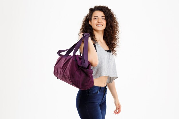 Sprawności fizycznej kędzierzawa dziewczyna trzyma sportową torbę
