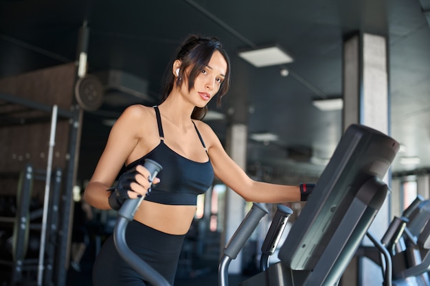 Sprawności fizycznej kobieta robi cardio w gym.