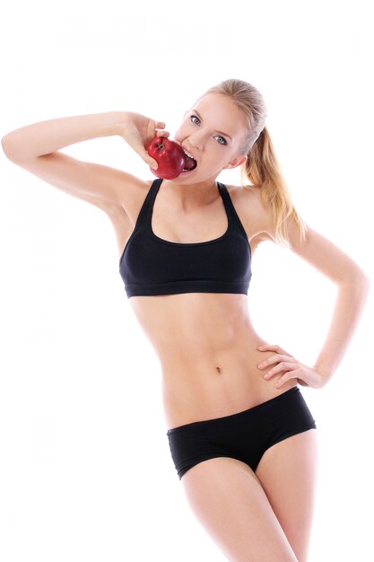 Sprawności fizycznej kobieta z seksownym ciałem trzyma czerwonego jabłka