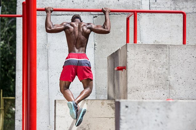 Bezpłatne zdjęcie sprawny sportowiec ćwiczeń na stadionie. afro lub afroamerykanin mężczyzna na zewnątrz w mieście