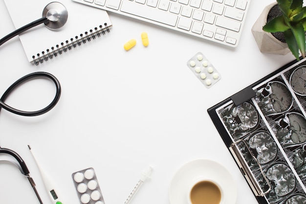 Bezpłatne zdjęcie sprzęt medyczny i repot z filiżanką kawy na biurku lekarza